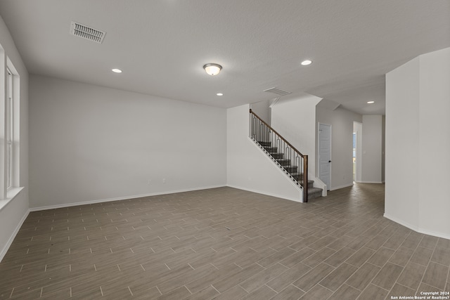 empty room with hardwood / wood-style floors and a textured ceiling