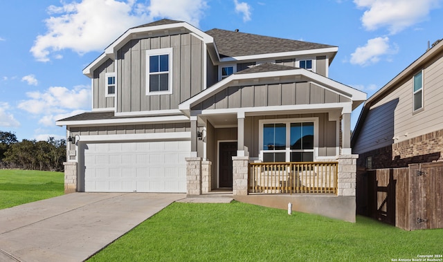 view of front of property featuring covered porch, a front lawn, and a garage