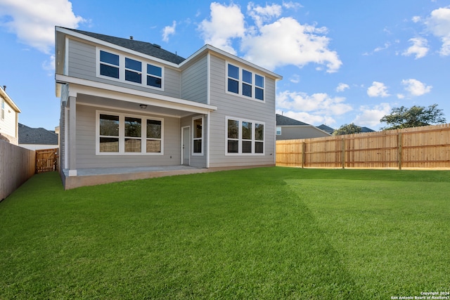 rear view of property featuring a patio and a yard