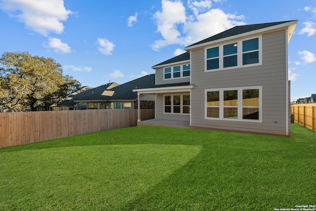 rear view of property with a patio area and a lawn