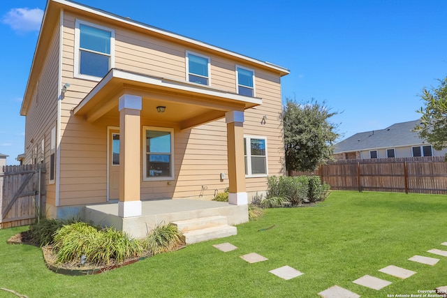 rear view of house featuring a yard