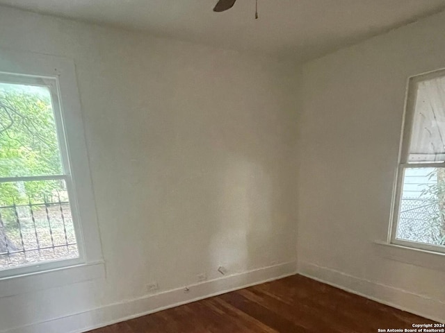 empty room featuring ceiling fan and dark hardwood / wood-style flooring