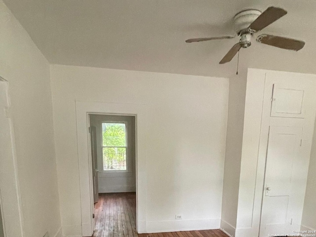 empty room with ceiling fan and dark hardwood / wood-style flooring