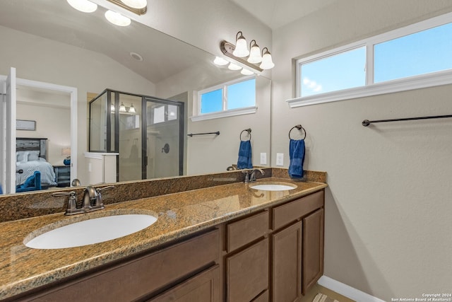 bathroom with vanity, vaulted ceiling, and a shower with shower door