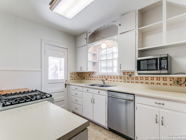 kitchen featuring sink, white cabinetry, light tile patterned floors, appliances with stainless steel finishes, and tasteful backsplash