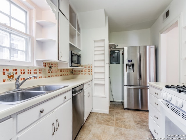 kitchen with appliances with stainless steel finishes, sink, decorative backsplash, and white cabinets