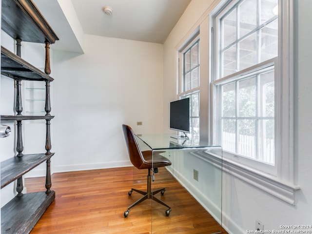 office featuring built in desk and hardwood / wood-style floors