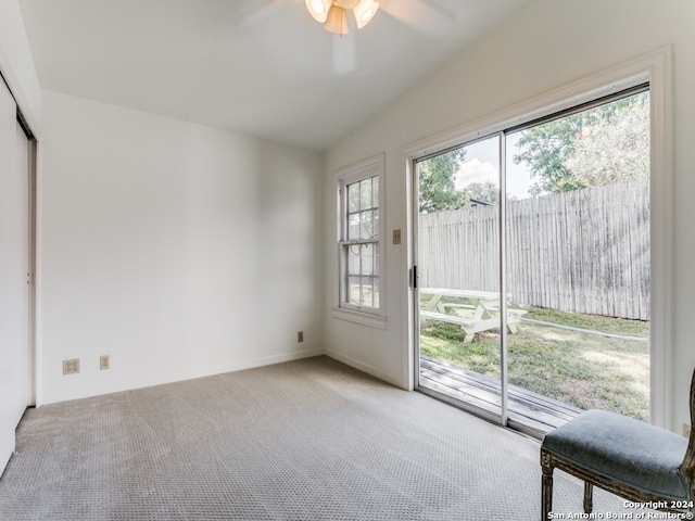 entryway with ceiling fan, a healthy amount of sunlight, lofted ceiling, and light colored carpet