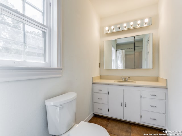 bathroom featuring toilet, vanity, and tile patterned flooring