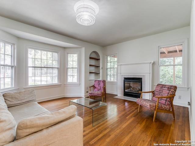 living room featuring a healthy amount of sunlight, wood-type flooring, and built in shelves