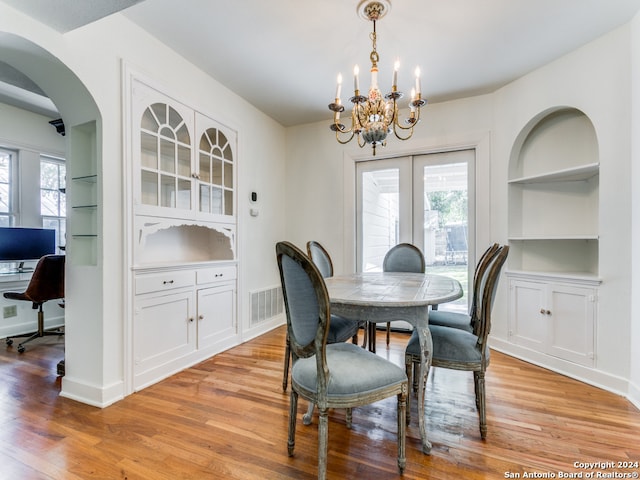 dining area featuring a wealth of natural light, built in features, and light hardwood / wood-style floors