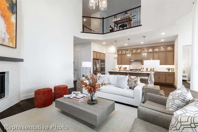 living room with a fireplace, dark hardwood / wood-style floors, and a high ceiling