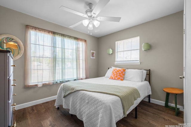 bedroom with ceiling fan, multiple windows, and dark hardwood / wood-style floors