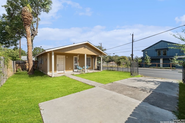 back of property featuring covered porch and a yard