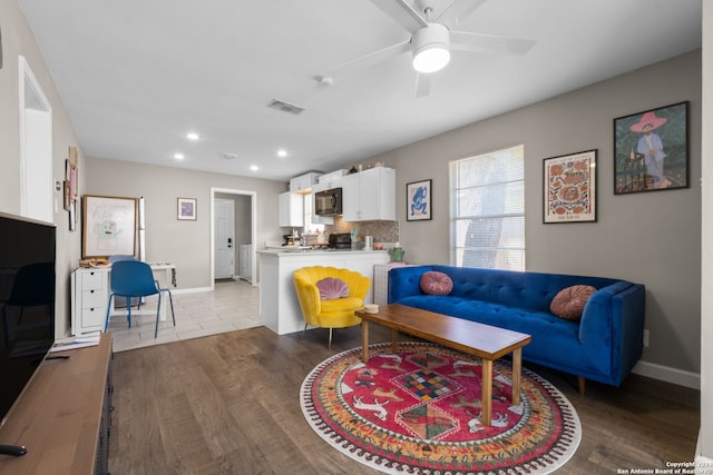 living room featuring light hardwood / wood-style flooring and ceiling fan