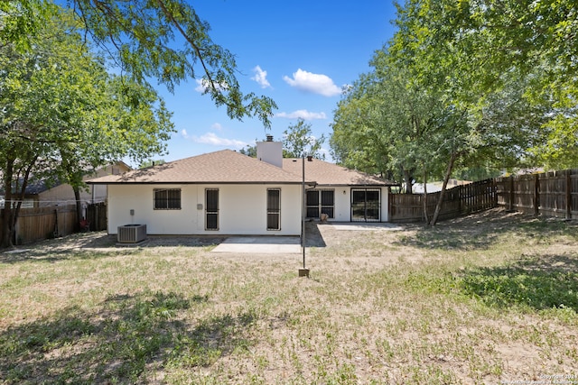 rear view of house featuring a patio, a lawn, and central AC unit