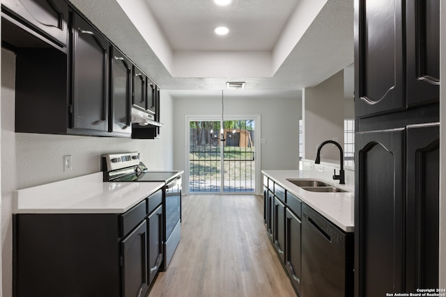 kitchen with a chandelier, light wood-type flooring, stainless steel appliances, sink, and decorative light fixtures