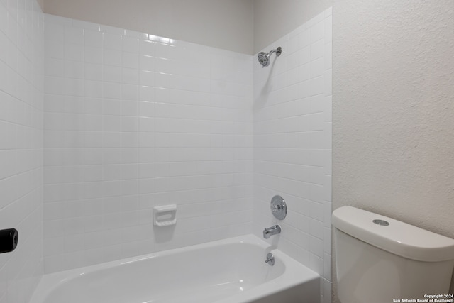 bathroom with toilet and tiled shower / bath