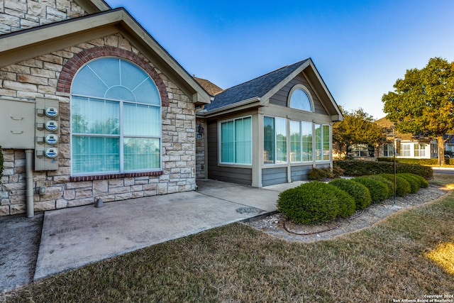 exterior space with a sunroom and a lawn