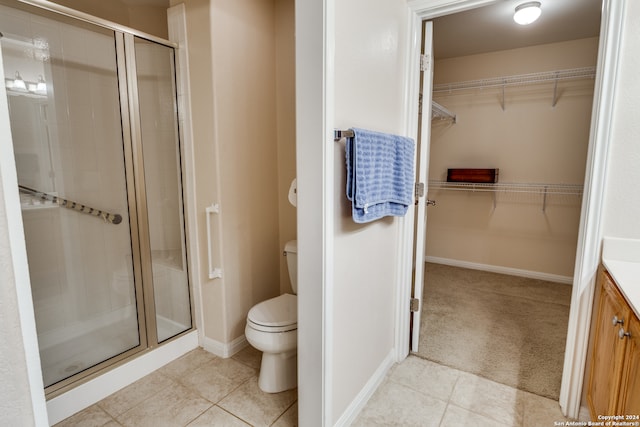 bathroom featuring vanity, toilet, tile patterned floors, and walk in shower