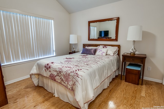 bedroom featuring vaulted ceiling and light hardwood / wood-style flooring