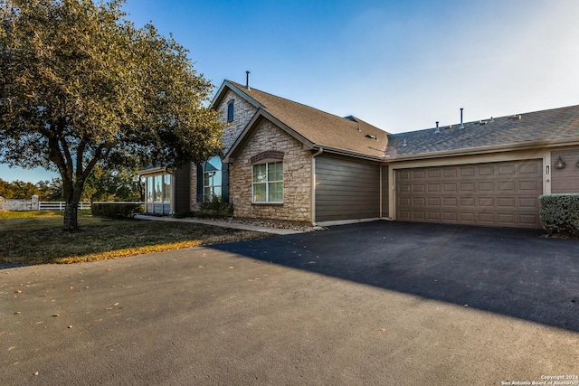 30 Wildwood Dr Unit 173, Georgetown, TX 78643 - view of front of property featuring a garage, stone siding, a shingled roof, and aphalt driveway