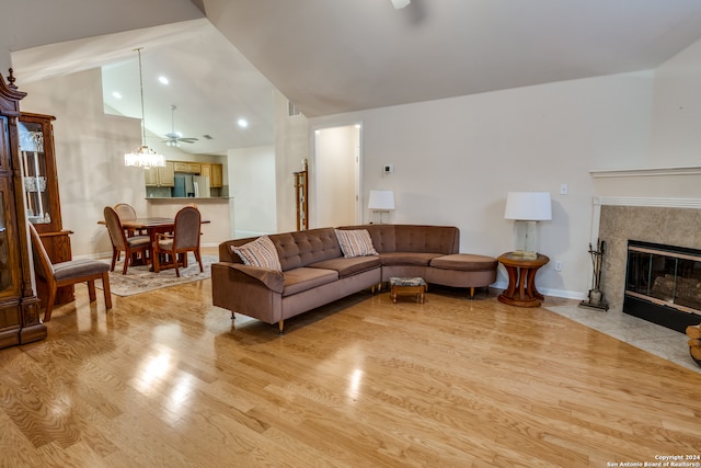 living room with lofted ceiling, light wood-type flooring, and ceiling fan