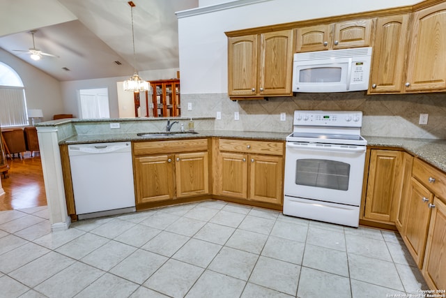 kitchen featuring lofted ceiling, kitchen peninsula, pendant lighting, sink, and white appliances