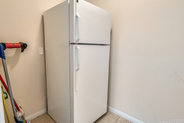 interior space with light tile patterned flooring and white refrigerator