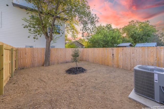 yard at dusk featuring central AC