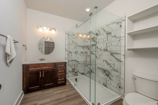 bathroom featuring hardwood / wood-style floors, vanity, toilet, and a shower with shower door