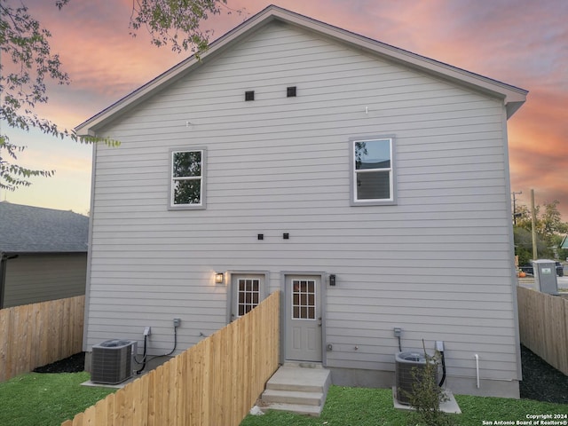 back house at dusk featuring central air condition unit