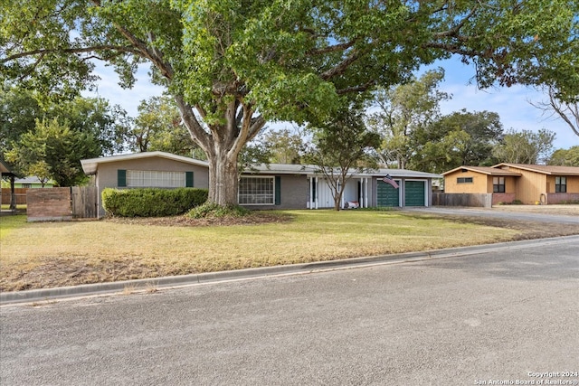 ranch-style home with a front lawn and a garage