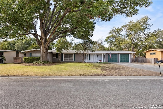 ranch-style home with a garage and a front lawn