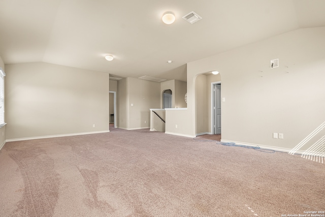 carpeted empty room with lofted ceiling