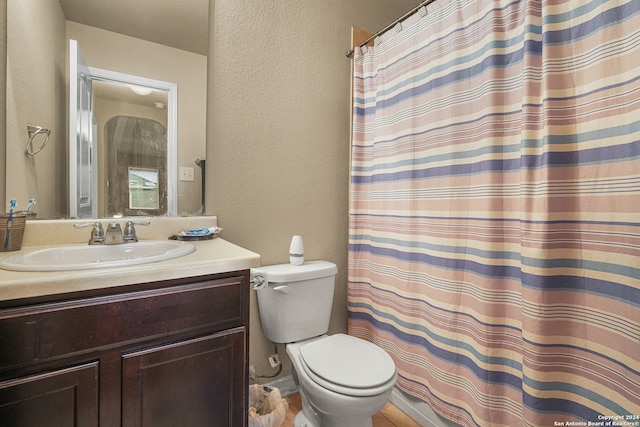 bathroom with toilet, a shower with curtain, and vanity