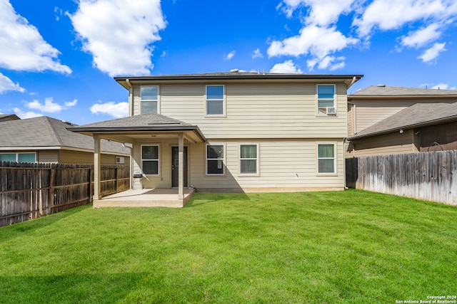 back of house featuring a patio area and a lawn