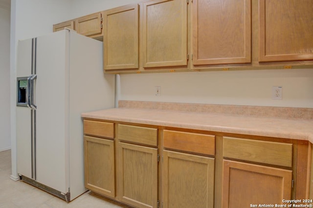 kitchen featuring white refrigerator with ice dispenser and light brown cabinets