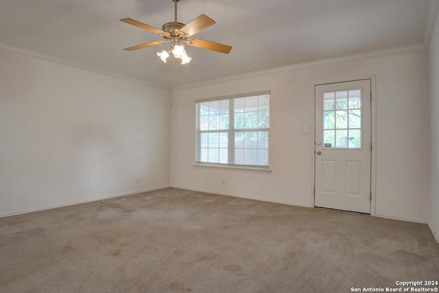 entryway featuring light carpet, ornamental molding, and ceiling fan