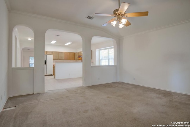 spare room with crown molding, lofted ceiling, and light colored carpet