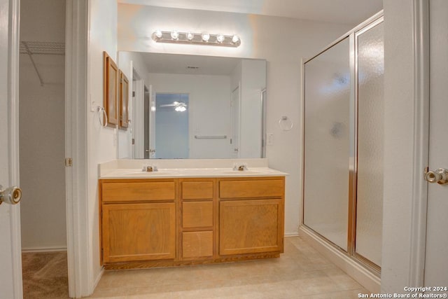 bathroom with vanity, tile patterned floors, and a shower with door