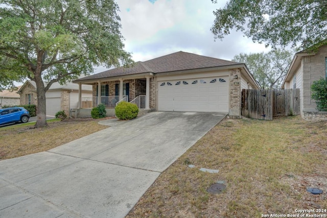 ranch-style house featuring a front yard, covered porch, and a garage