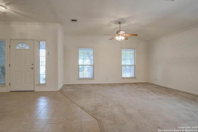 foyer with ornamental molding, light colored carpet, lofted ceiling, and ceiling fan