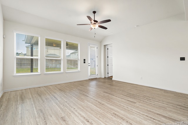 empty room featuring light hardwood / wood-style floors, vaulted ceiling, and ceiling fan