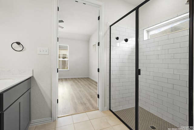 bathroom featuring vanity, hardwood / wood-style flooring, a shower with shower door, and plenty of natural light