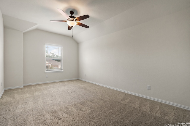 carpeted spare room featuring ceiling fan and vaulted ceiling