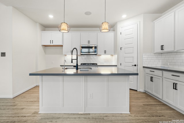 kitchen with white cabinets and a kitchen island with sink