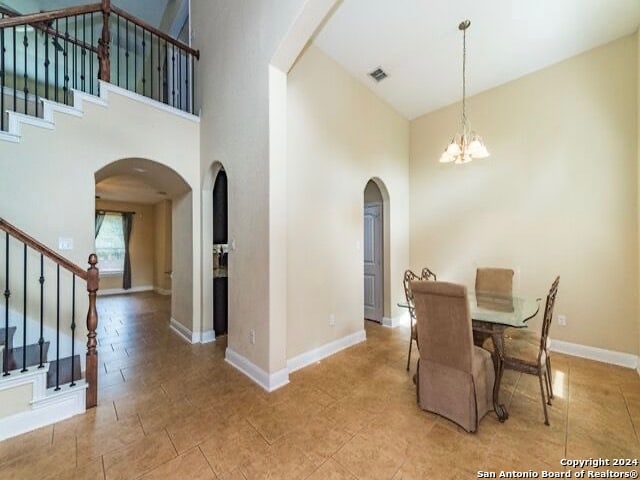 dining room with a notable chandelier and a high ceiling