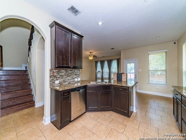 kitchen featuring sink, backsplash, dark brown cabinets, kitchen peninsula, and stainless steel dishwasher