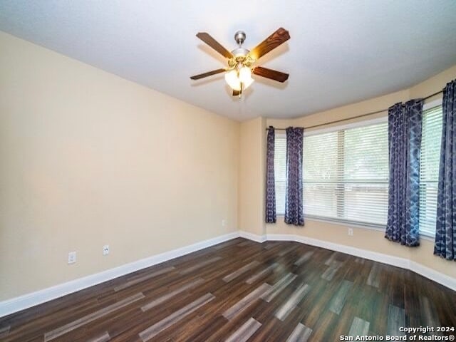 spare room featuring ceiling fan and dark hardwood / wood-style flooring